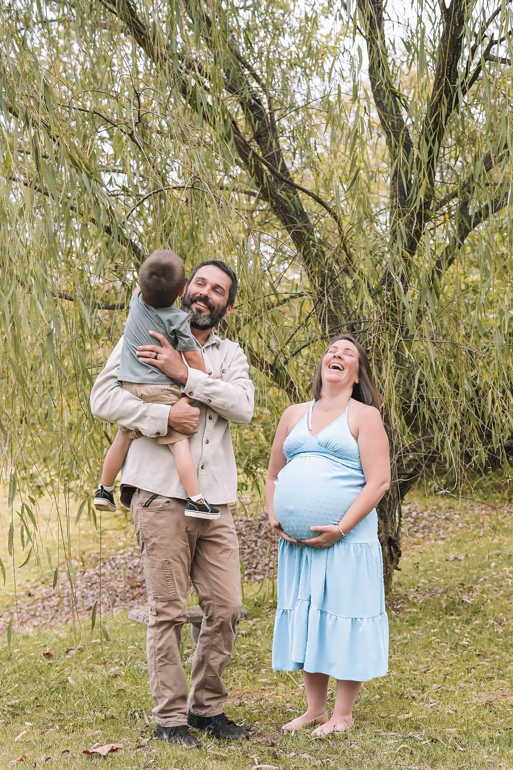 A loving family moment captured in a series of candid photos under a willow tree in a natural outdoor setting. Leesburg, Virginia