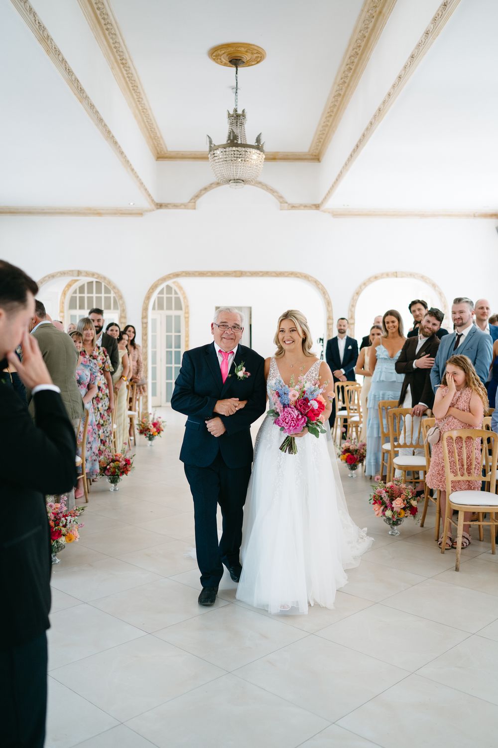 A sequence of dance moves at an elegant wedding reception in a bright white room with ornate crown molding.
