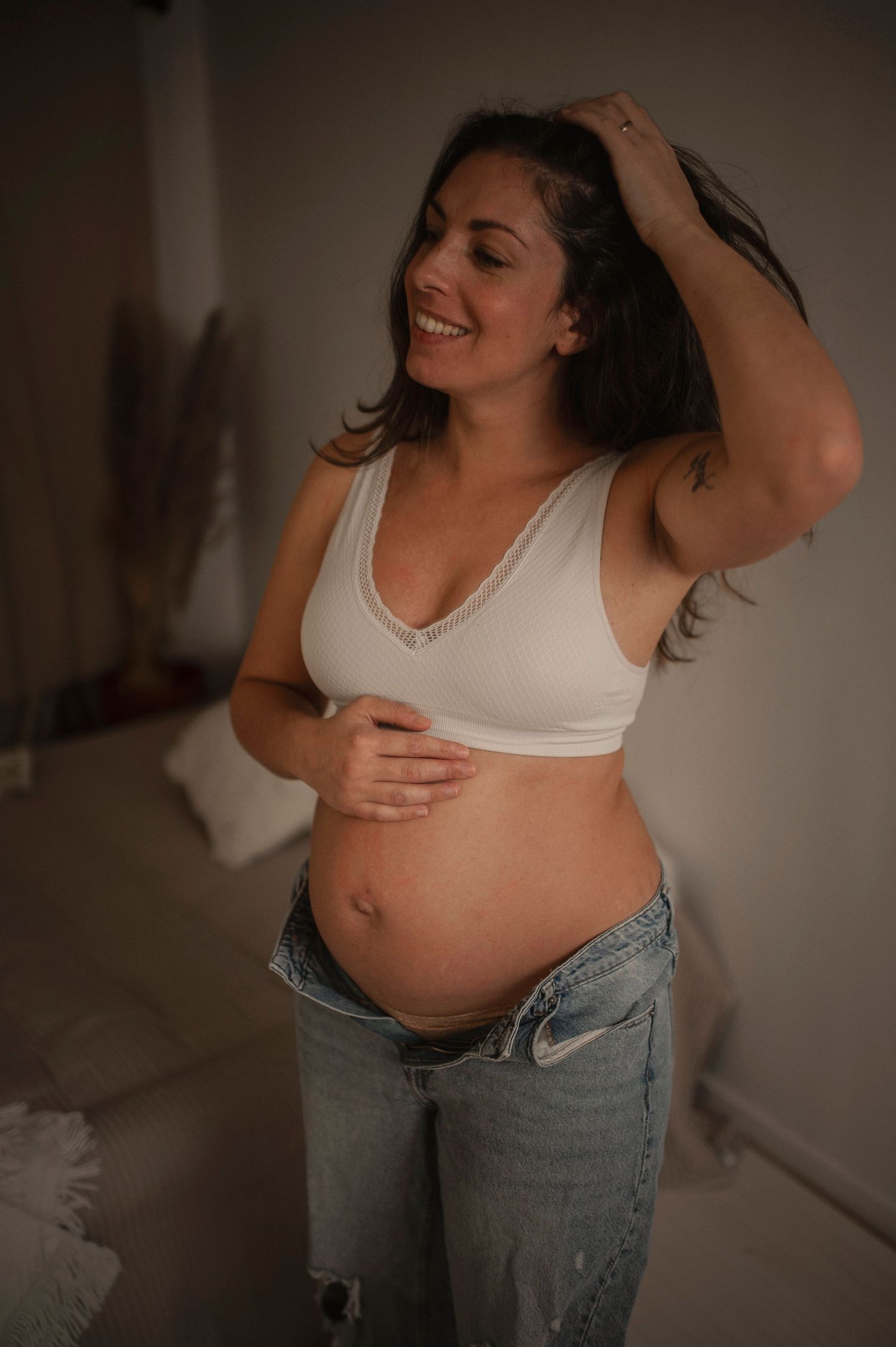 Vacker gravid kvinna som dansar på sin gravidfotografering i Lovestories By Saras bohemiska studio.