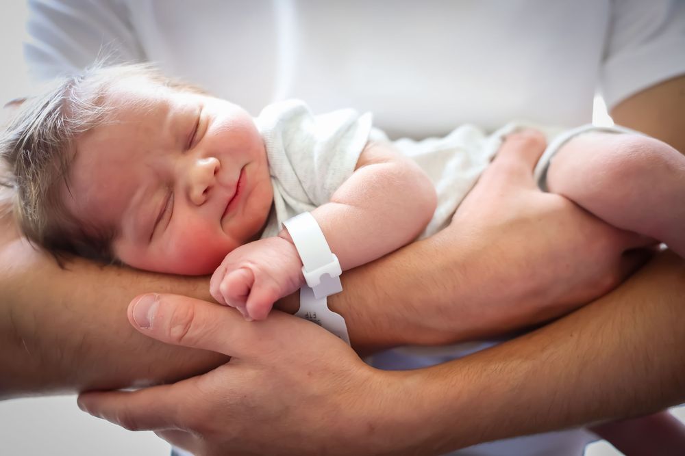 Peaceful moments captured of sleeping infant resting on adult's chest.