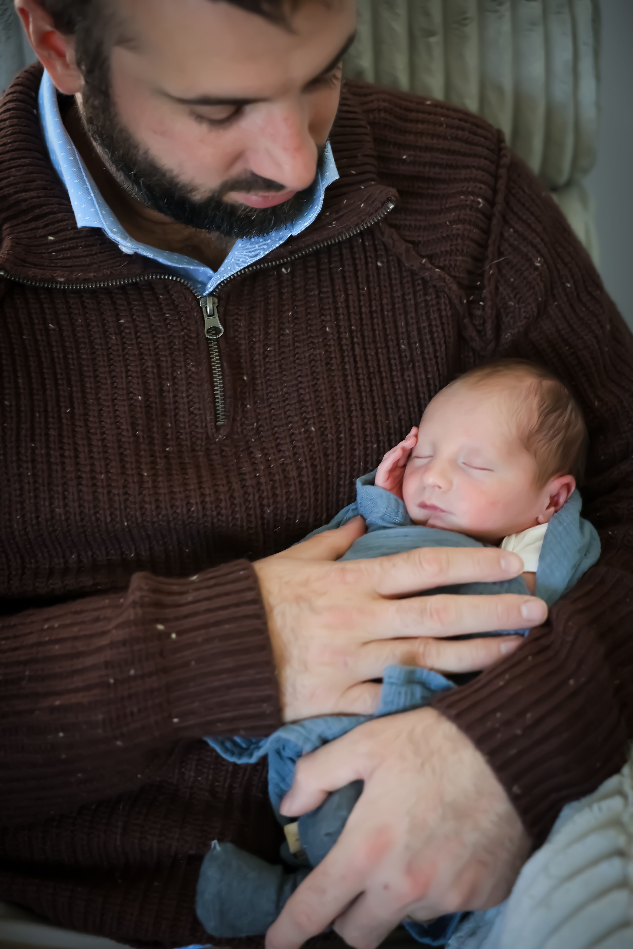 Sequence showing gentle moments between adult and infant in brown sweater.