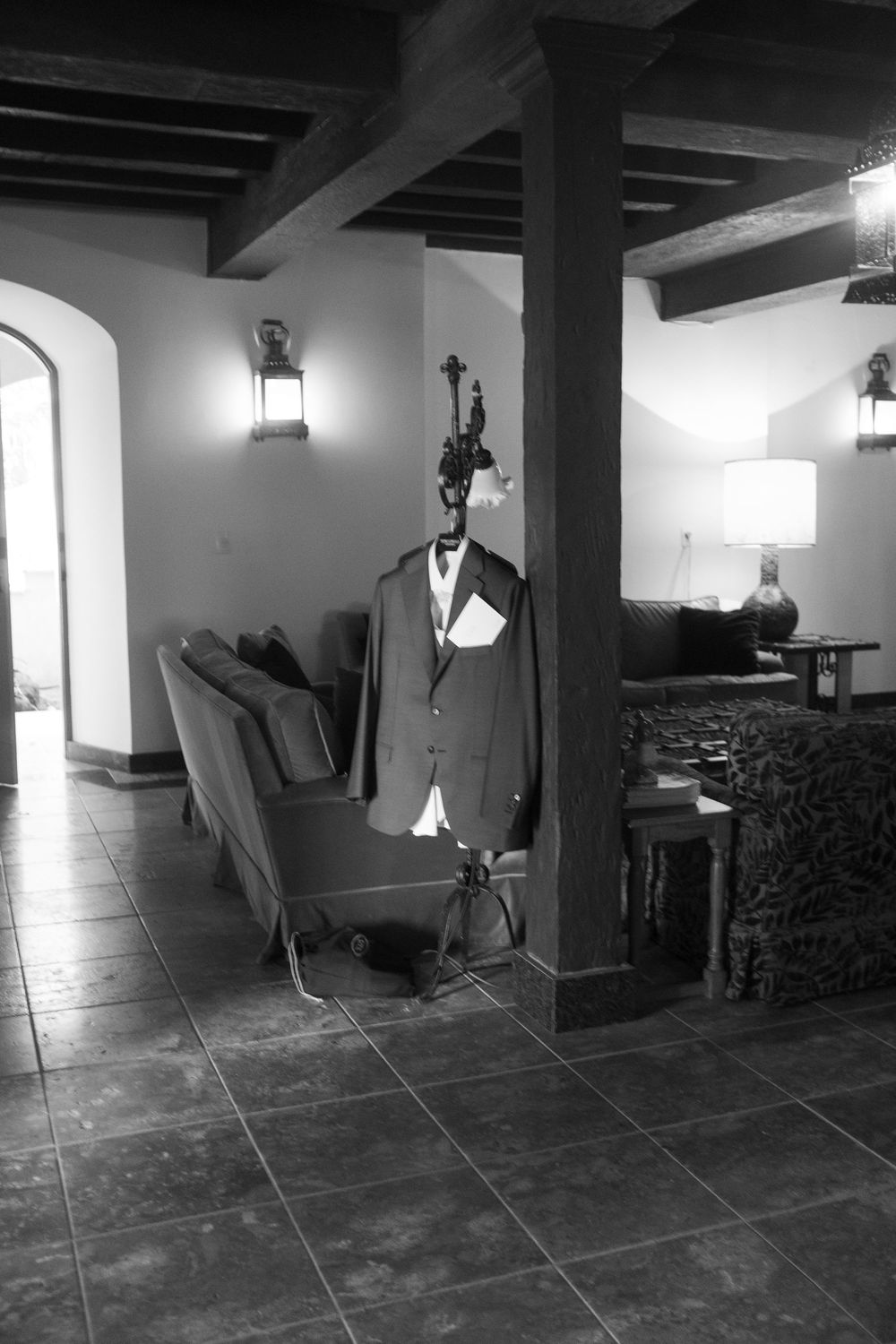 Black and white photo sequence showing movement across a dimly lit room with exposed beams and tiled floor.