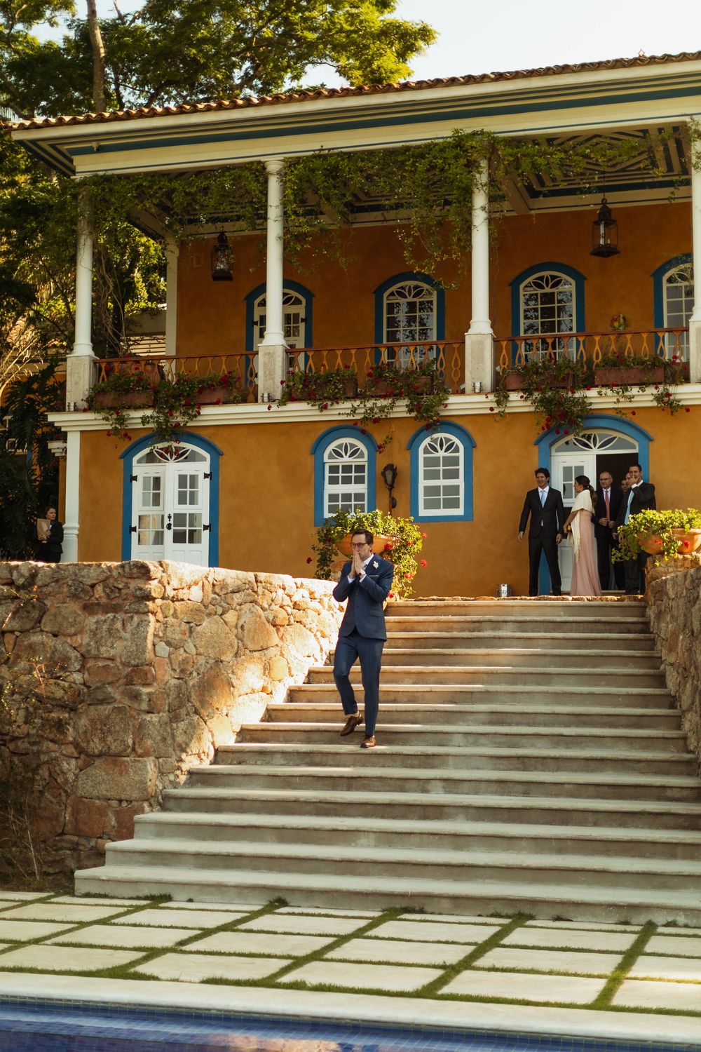 A sequence of photos showing a person walking down stone steps at a Spanish colonial style building with arched windows.