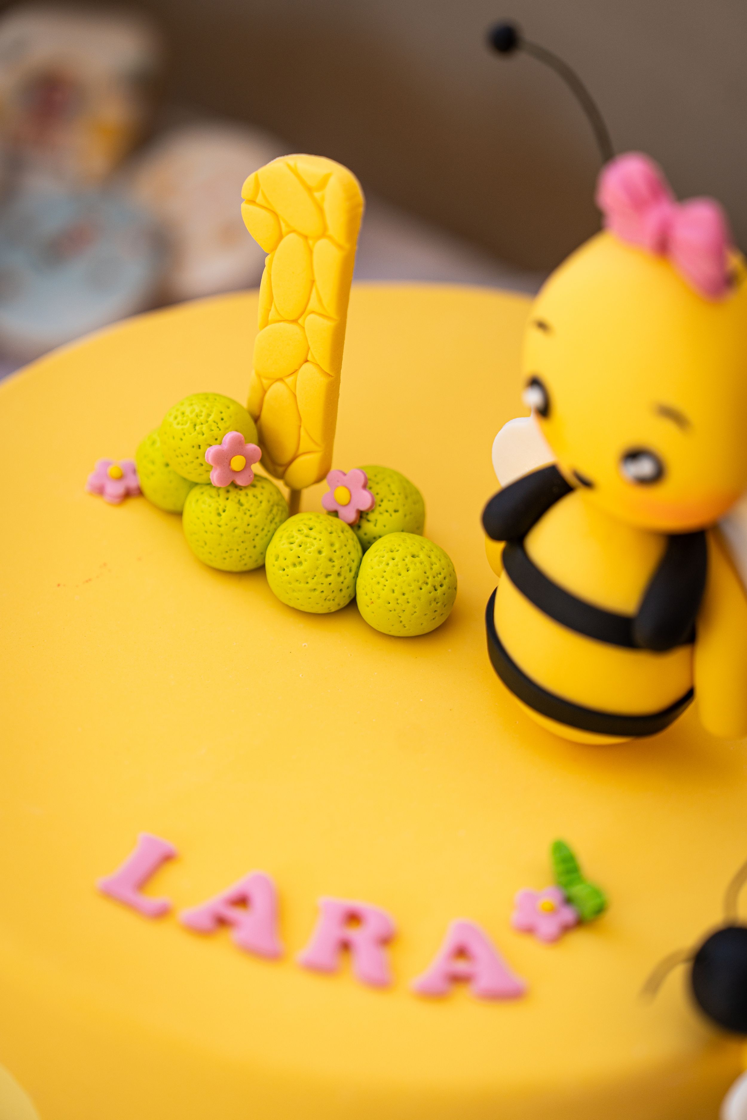 Close-up details of a yellow bee-themed birthday cake with decorative elements.