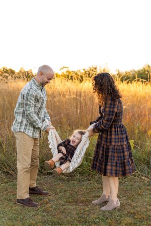 Playful family moment captured in golden field Nj Family Photographer in Sussex County
