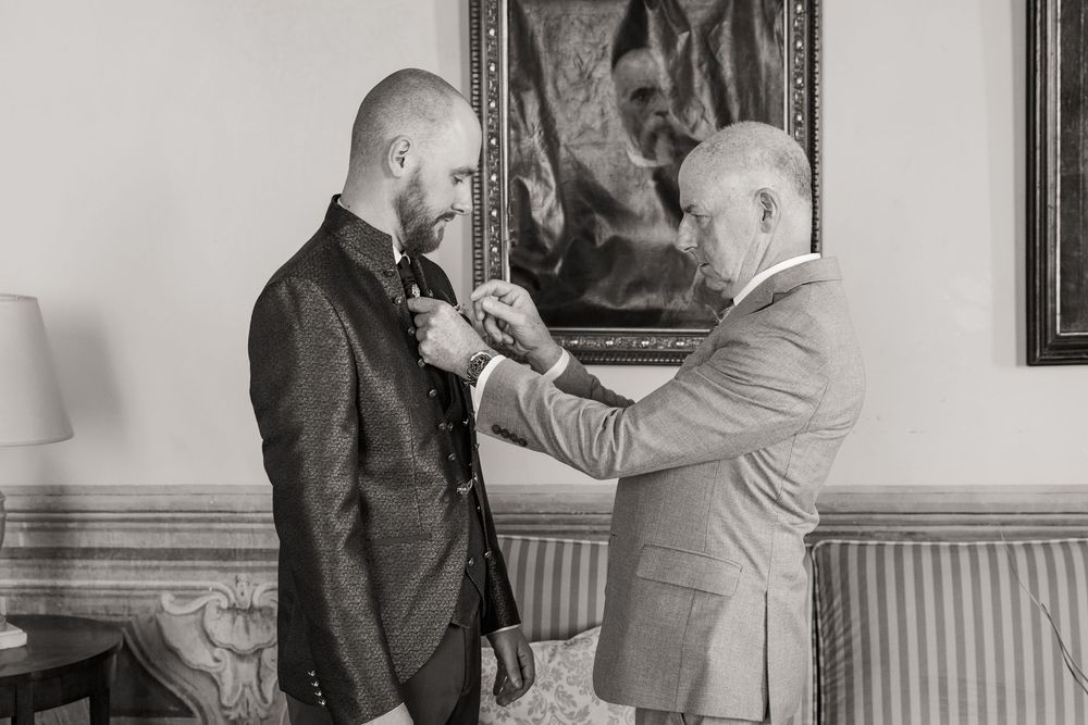 A series of black and white photographs showing someone being fitted for a suit at a tailor shop.