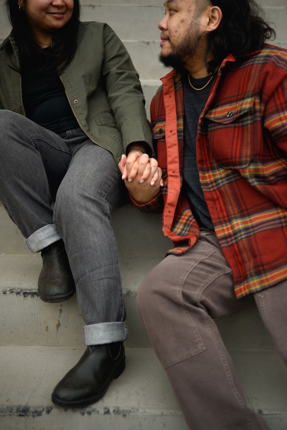 A series of close-up shots showing feet in black boots and gray pants next to someone wearing a red plaid shirt.