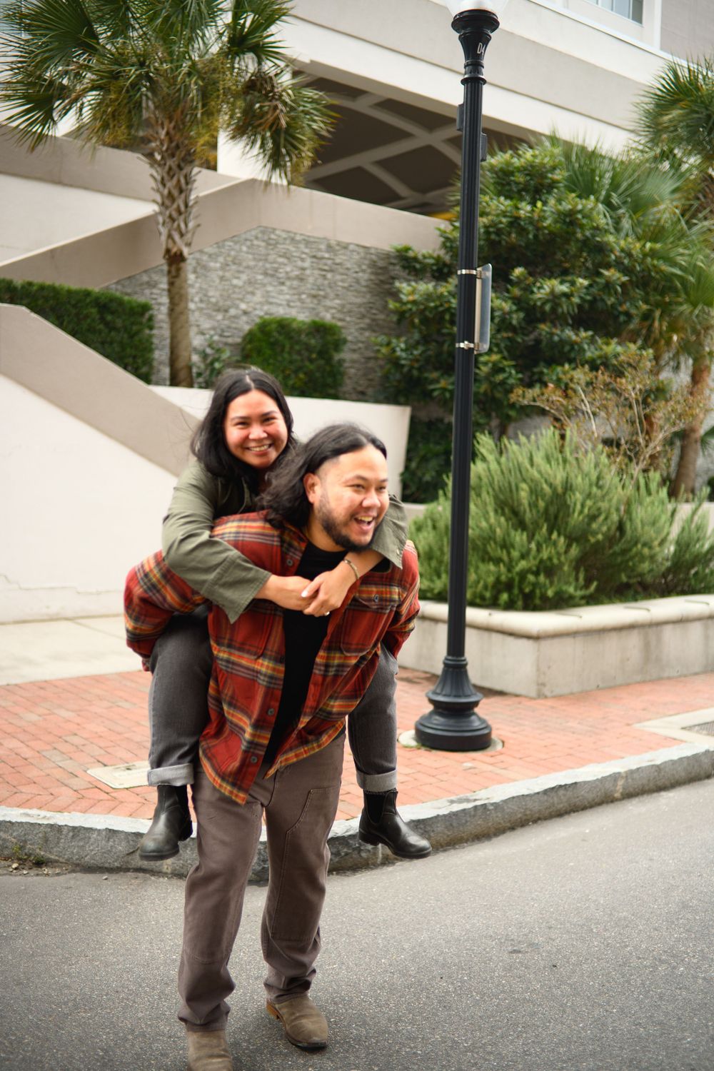 Four sequential photos showing a person in a plaid shirt and brown pants playfully posing on a brick walkway near palm trees.