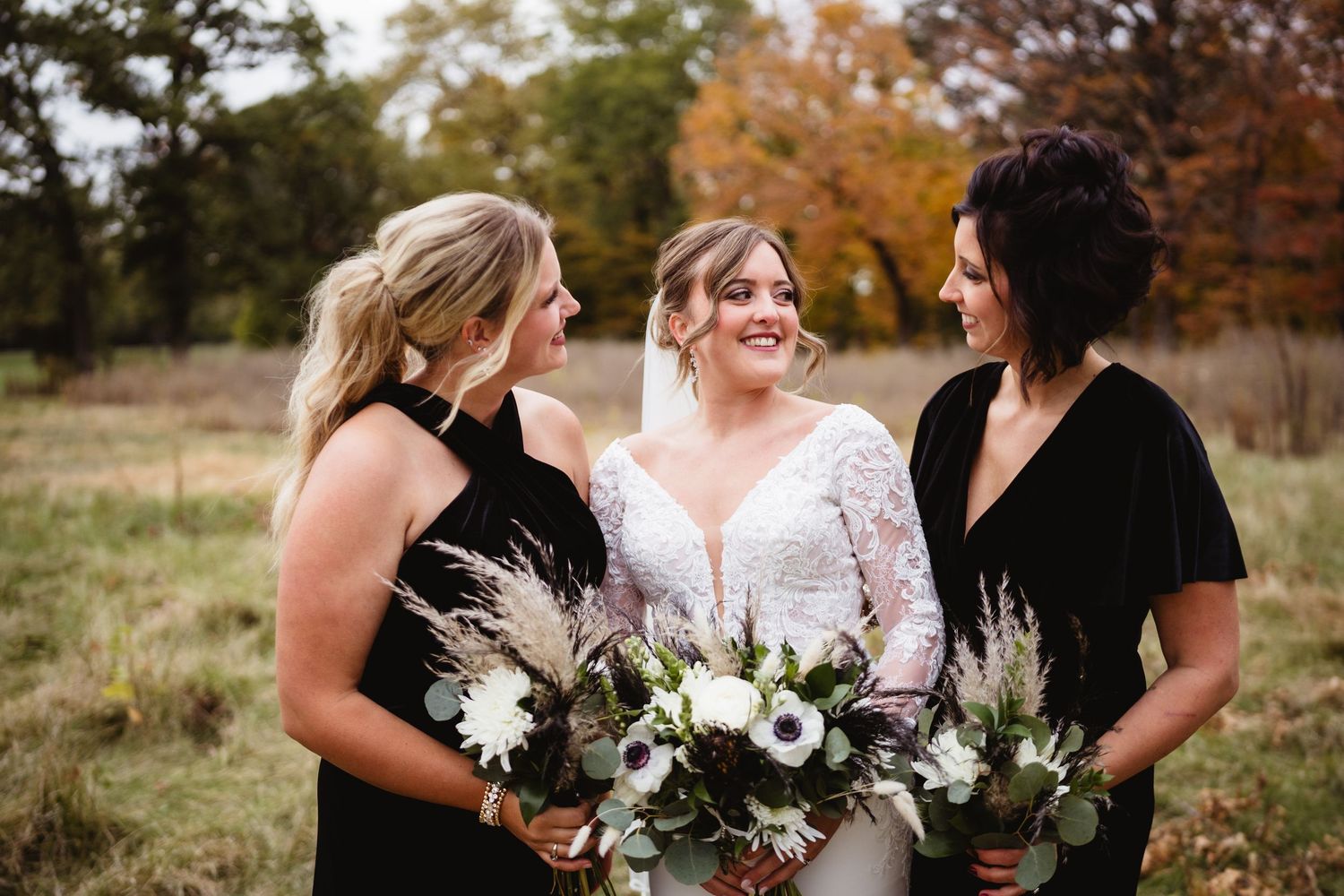 A group in formal attire shares joyful laughter together during an autumn outdoor photo session.