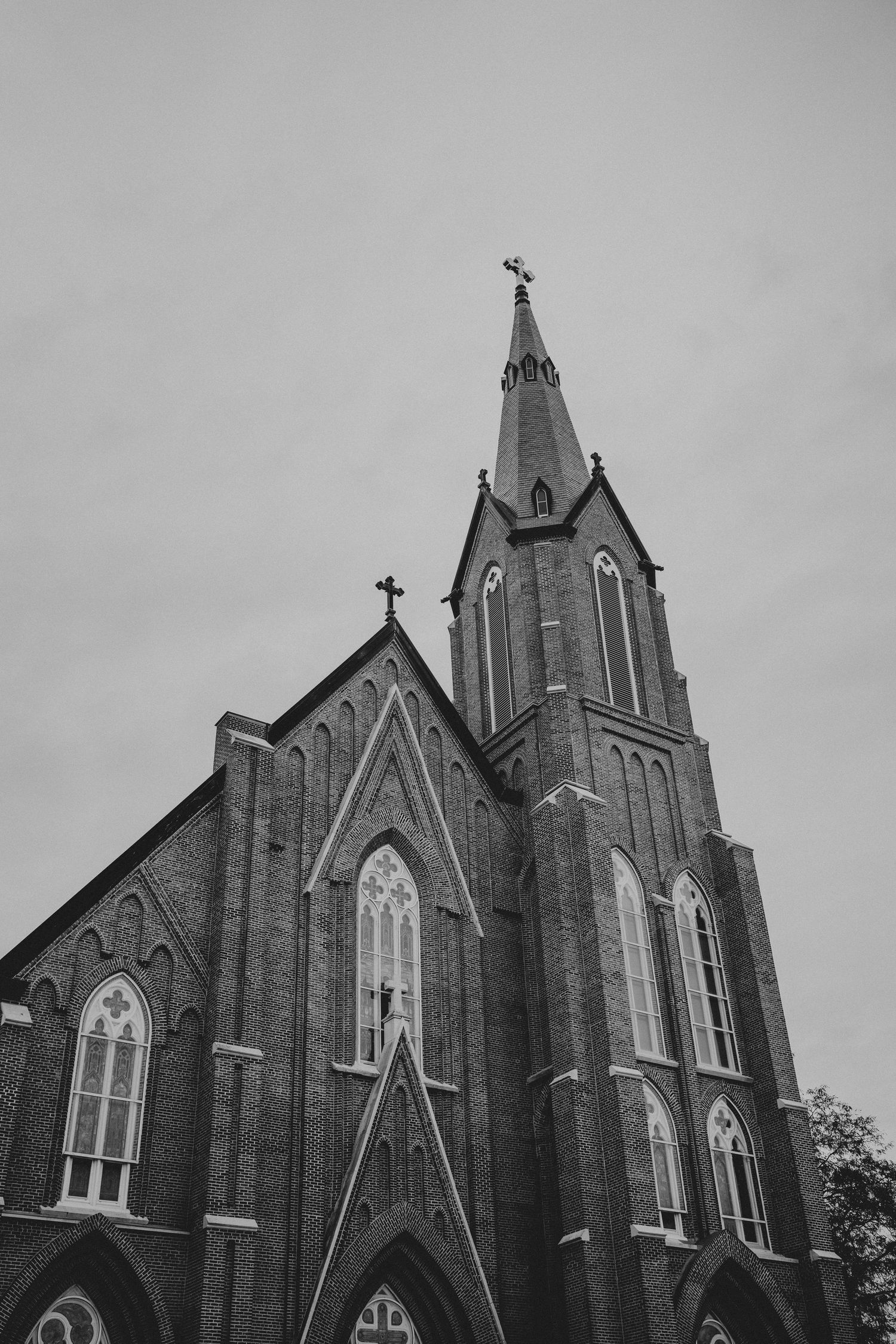 Gothic church spires and steeples rise dramatically against an overcast sky in black and white photography.