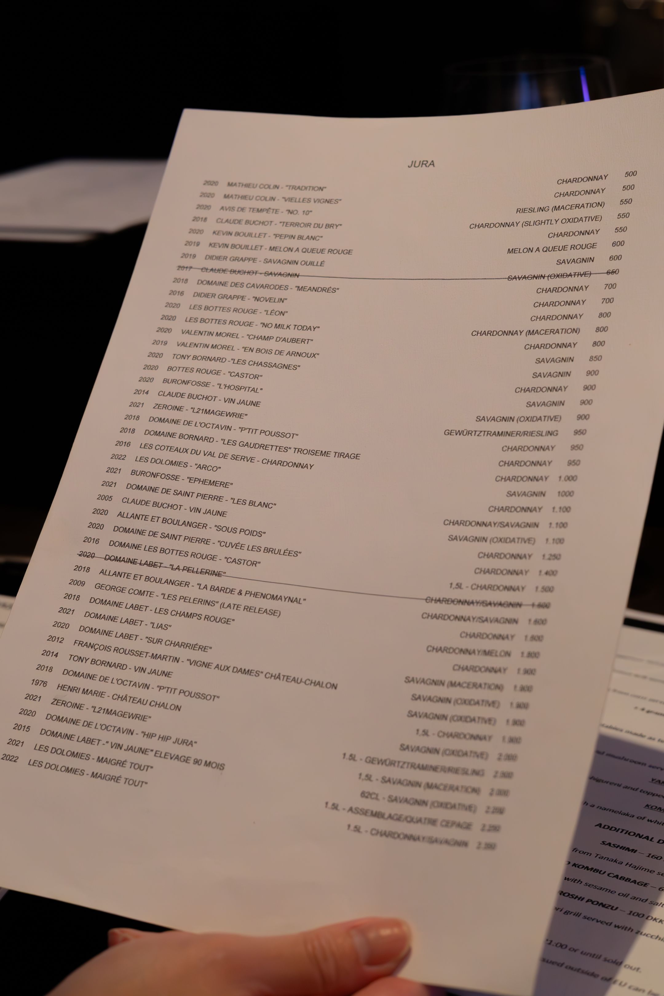 Restaurant menu pages displayed on a wooden table showing various food and beverage options.