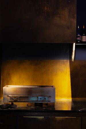 Dimly lit restaurant interior with warm yellow lighting and dark wooden furnishings.