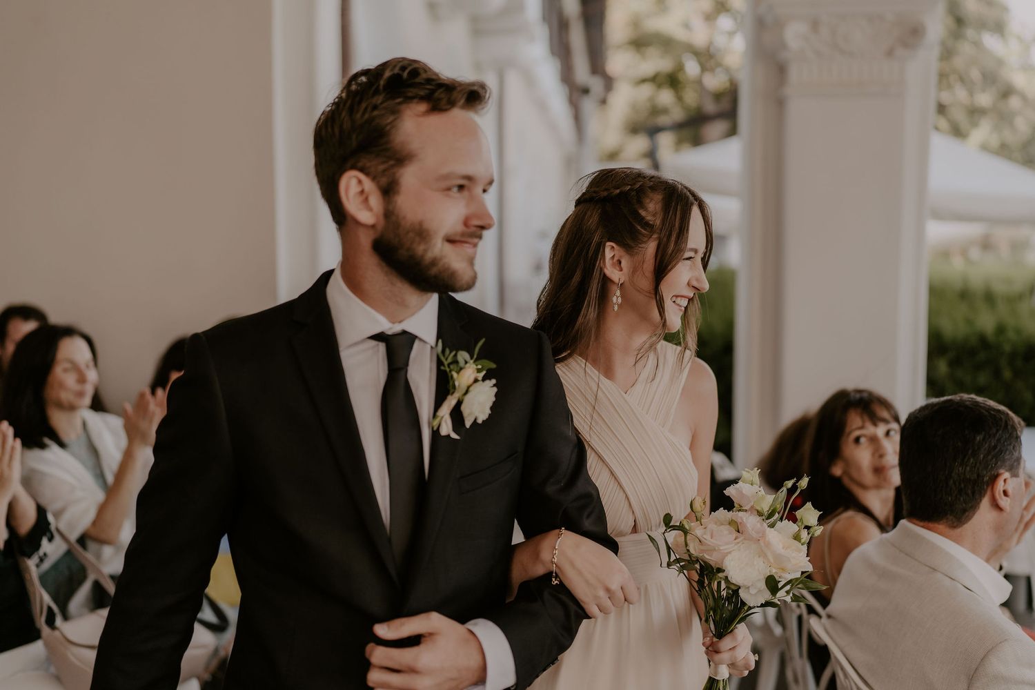 Wedding guests mingle and embrace during an elegant reception.