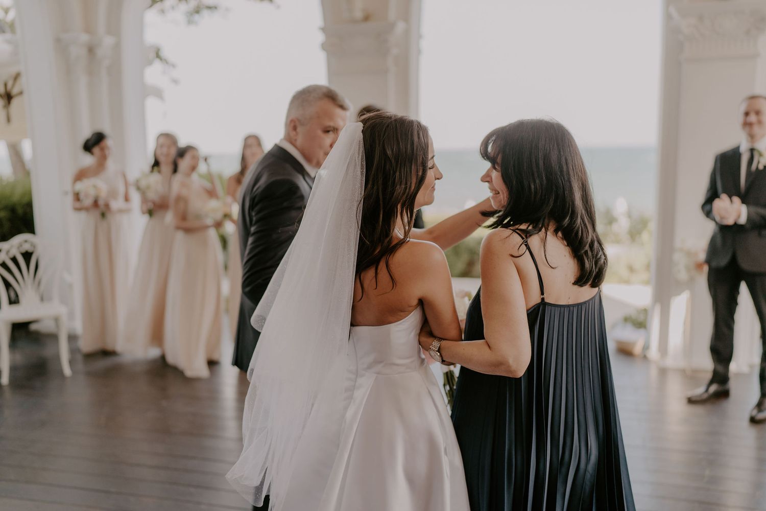 Guests gather under white archways during an elegant wedding celebration.