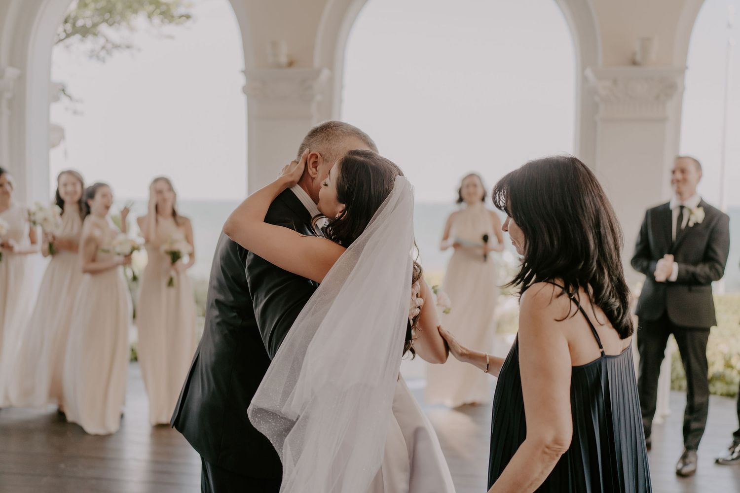 Wedding celebration moments captured under beautiful white archways.