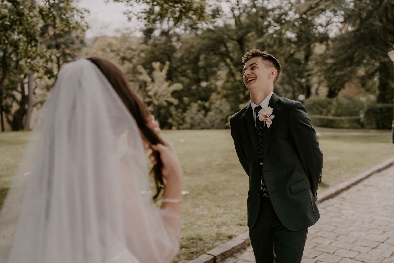 A romantic first look between newlyweds in an outdoor garden setting.
