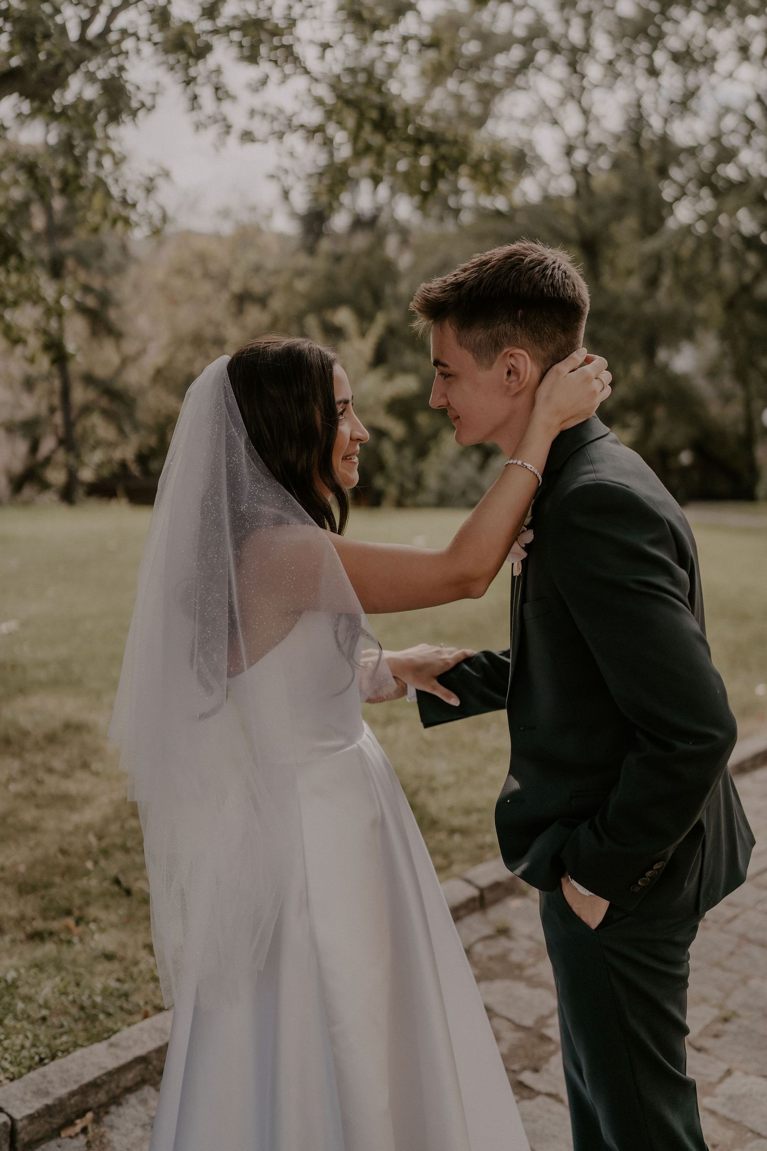 An intimate moment between newlyweds during their first look on a stone pathway.