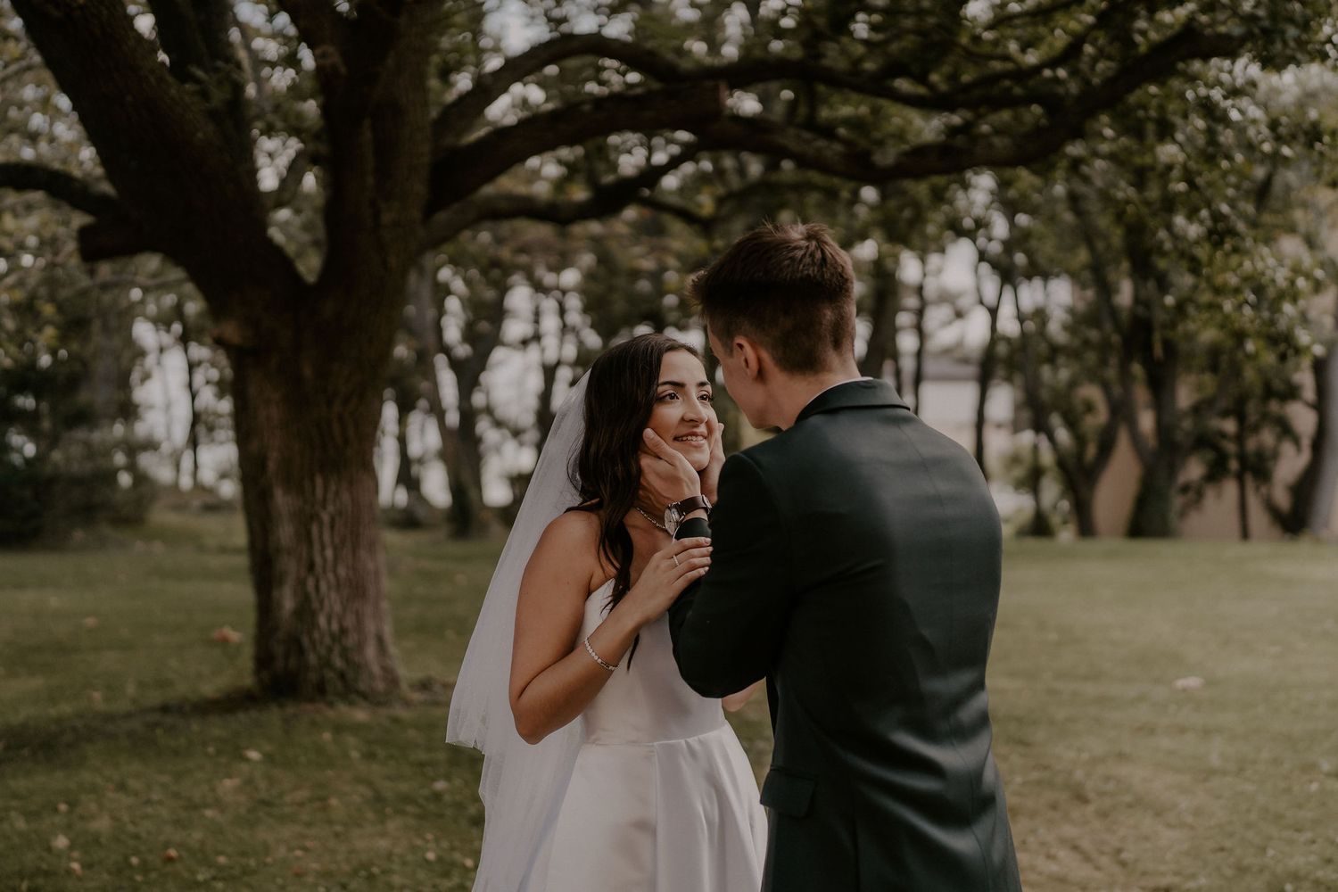 A joyful emotional moment between a bride and groom during their outdoor wedding.