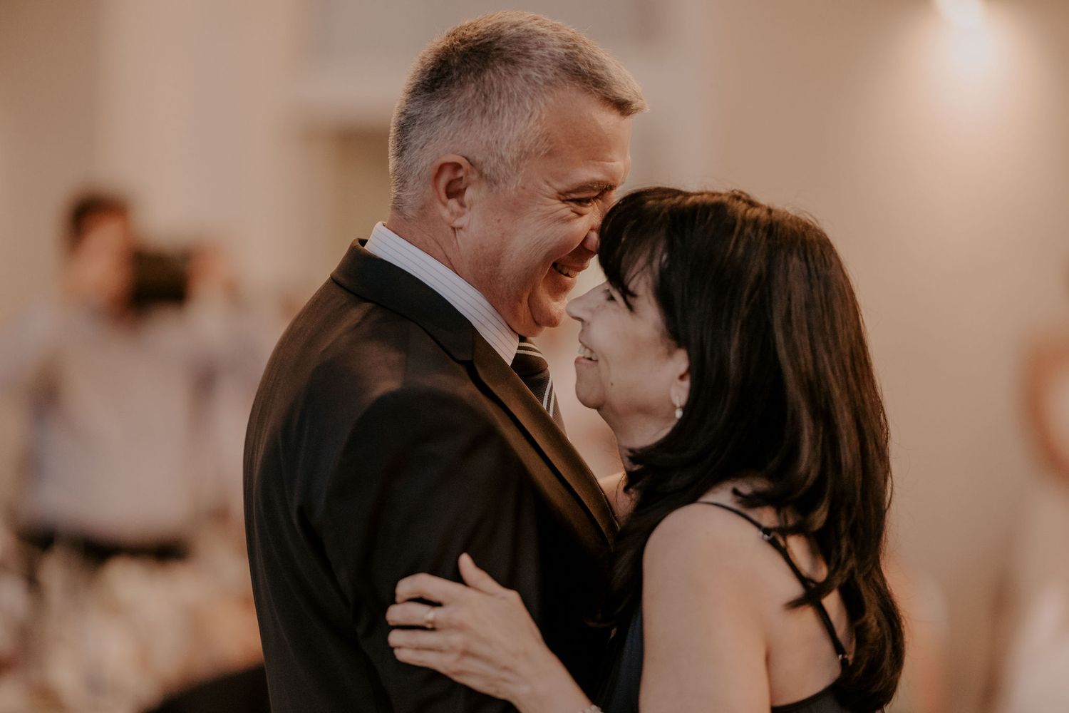 Couple shares a tender slow dance moment at their indoor wedding reception.