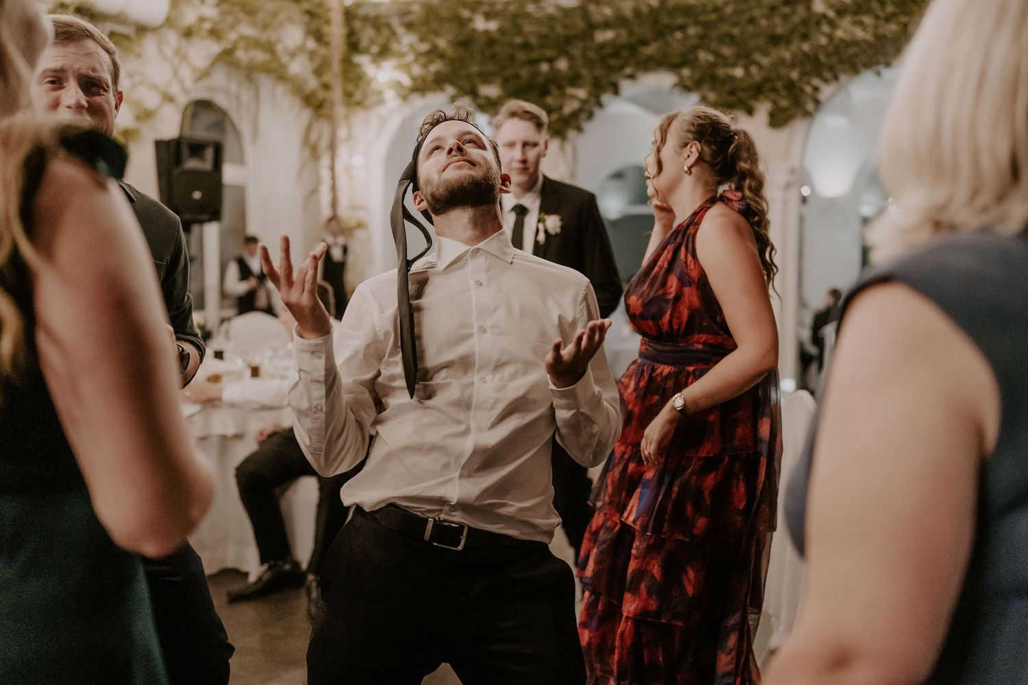 Wedding guests dance and celebrate together at an outdoor evening reception.