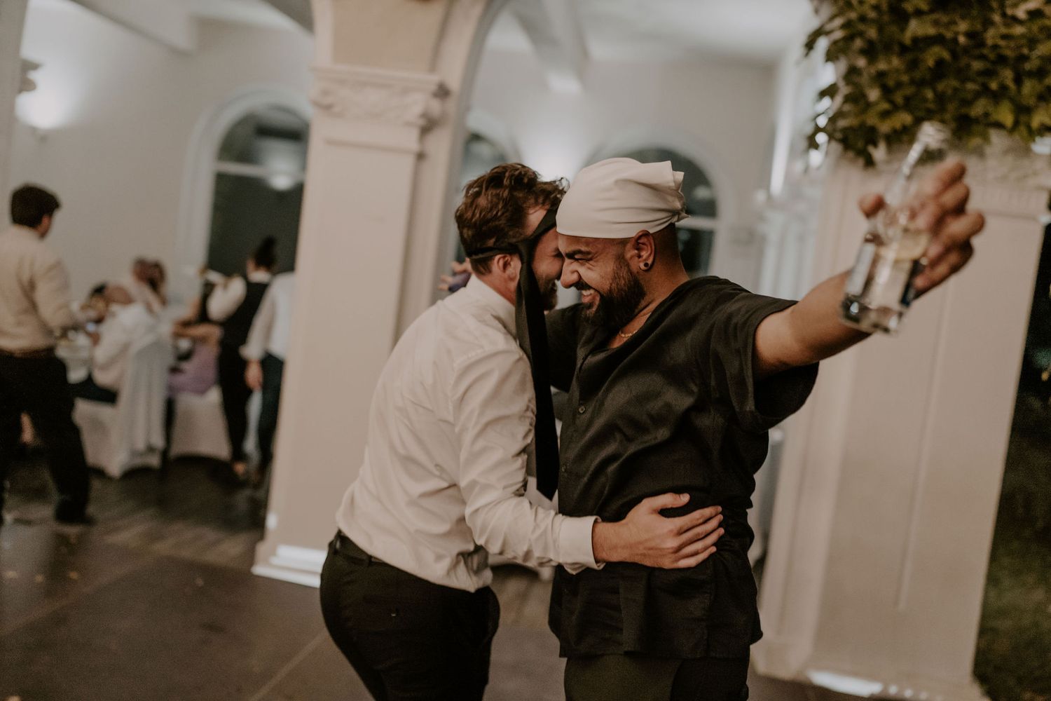Wedding guests mingle and socialize during a lively outdoor celebration.