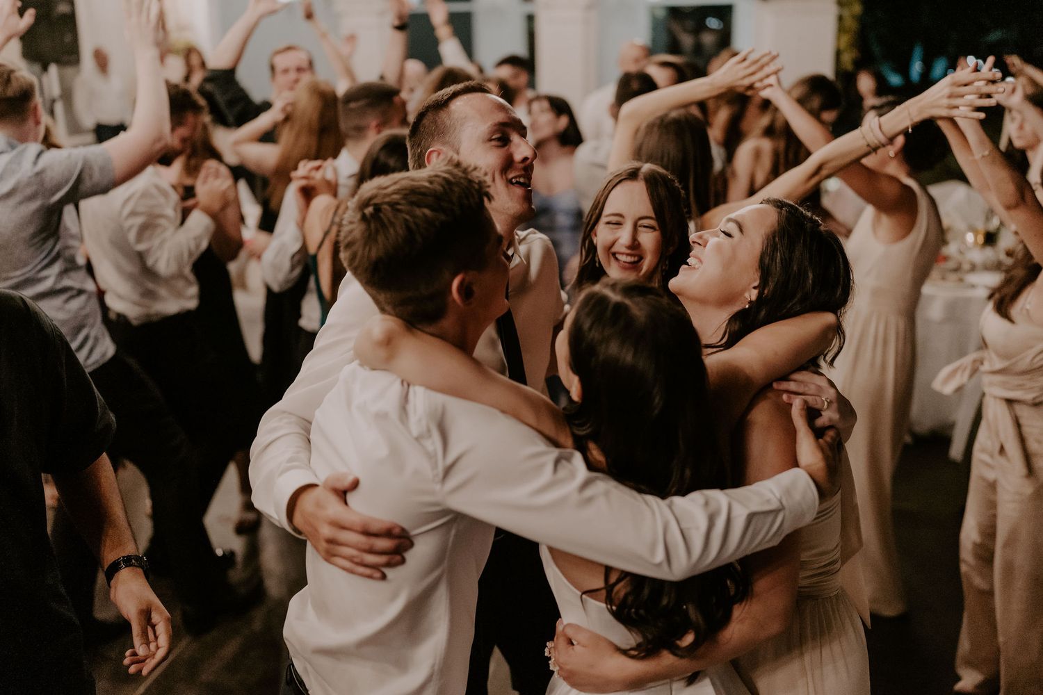 Wedding reception dance floor filled with guests celebrating in a lively atmosphere.
