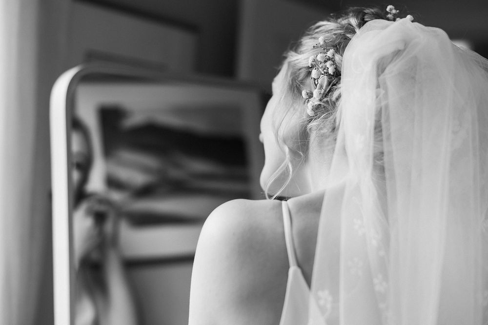 Black and white detail shot of wedding preparations with soft focus and natural light.