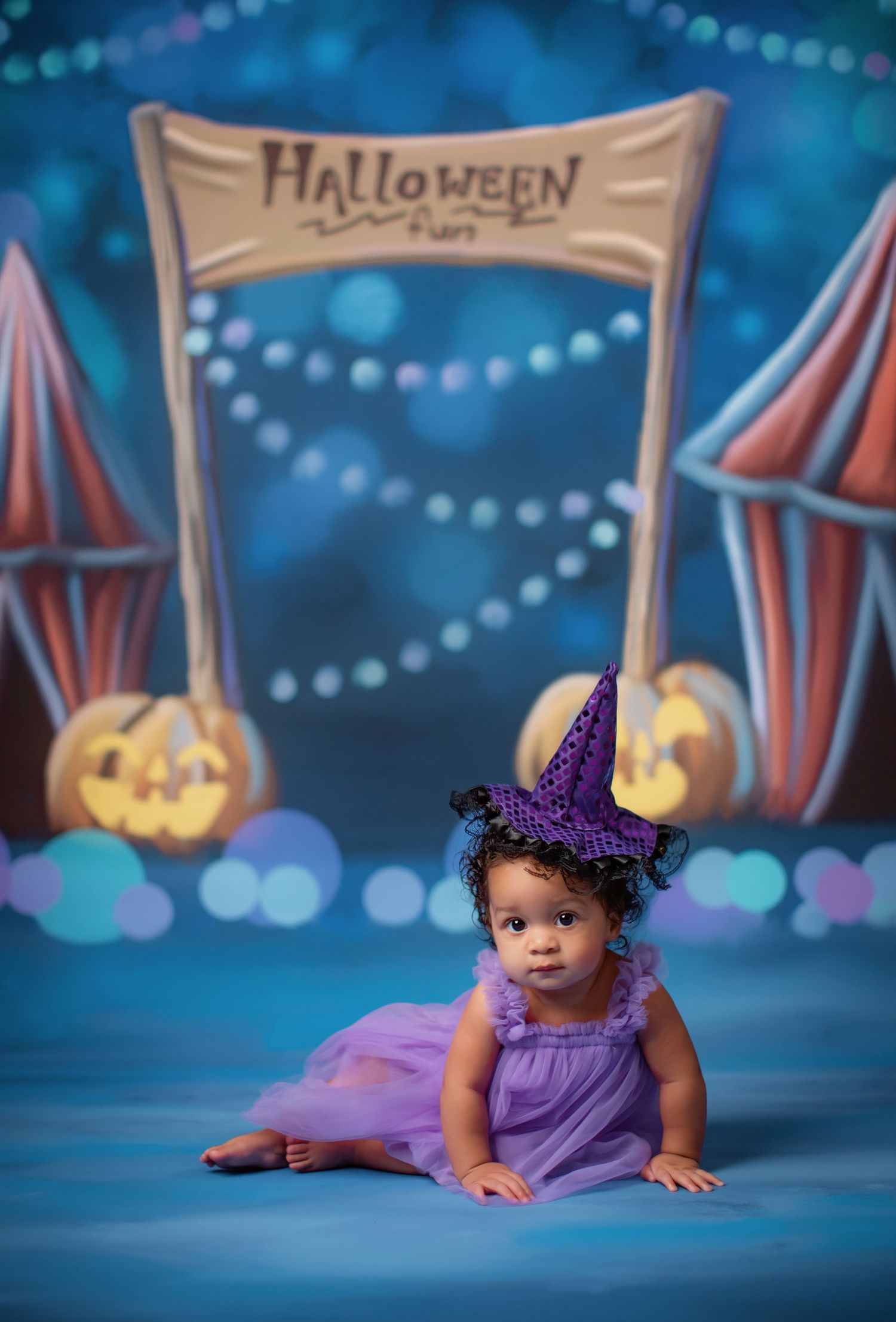 Purple tulle dress portrait with large bow backdrop and floral decorations.