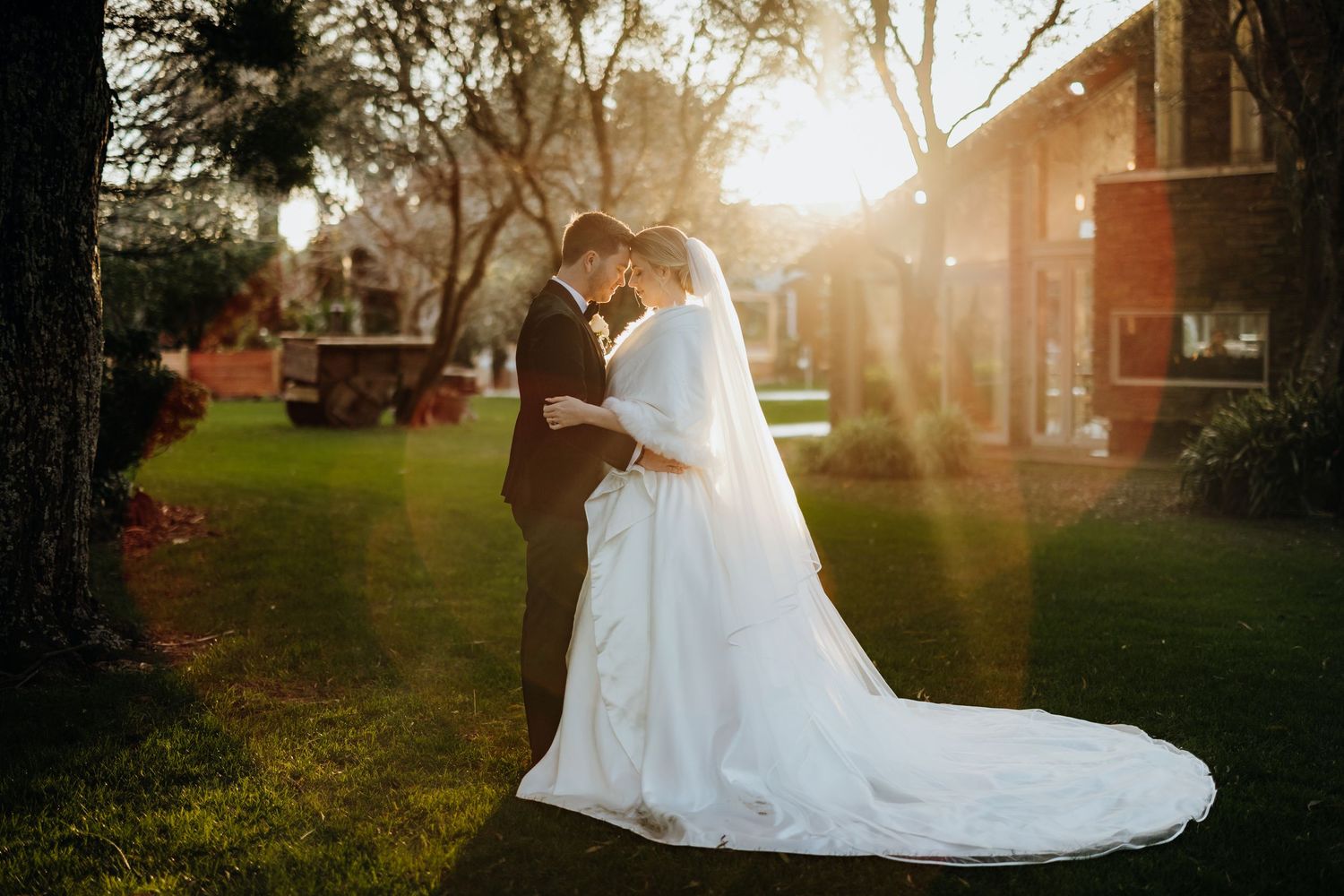 Romantic garden wedding ceremony setup with white chairs and floral arrangements lining the outdoor aisle.