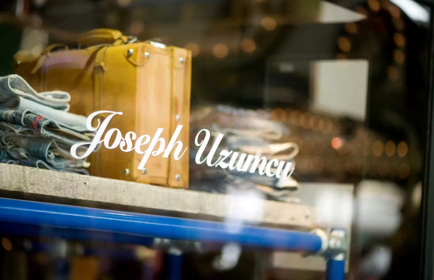 Storefront window with elegant script lettering in dark lighting.