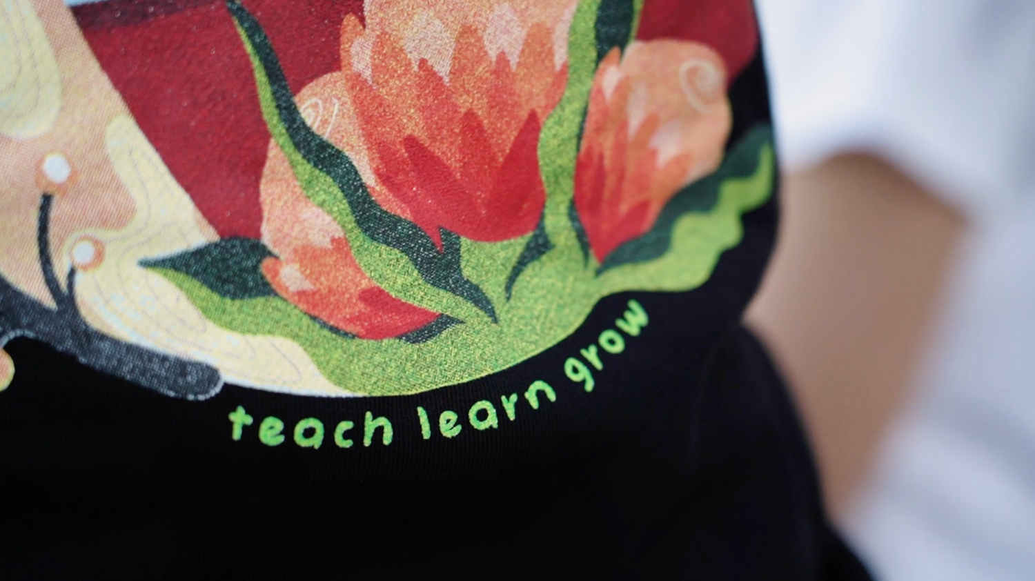 Colorful floral pattern detail with text on fabric or printed material.