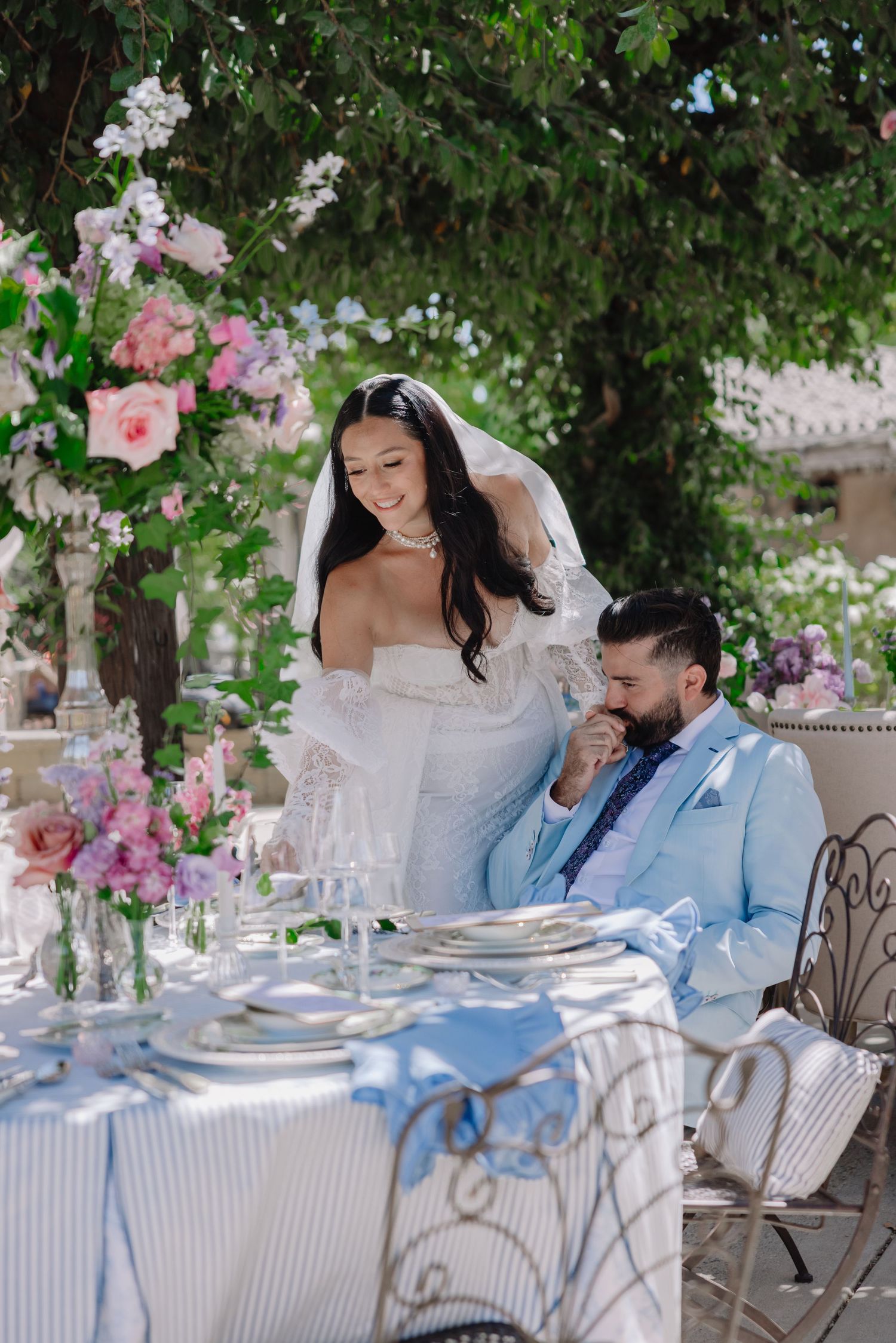Elegant garden wedding reception table with pink and white floral arrangements.