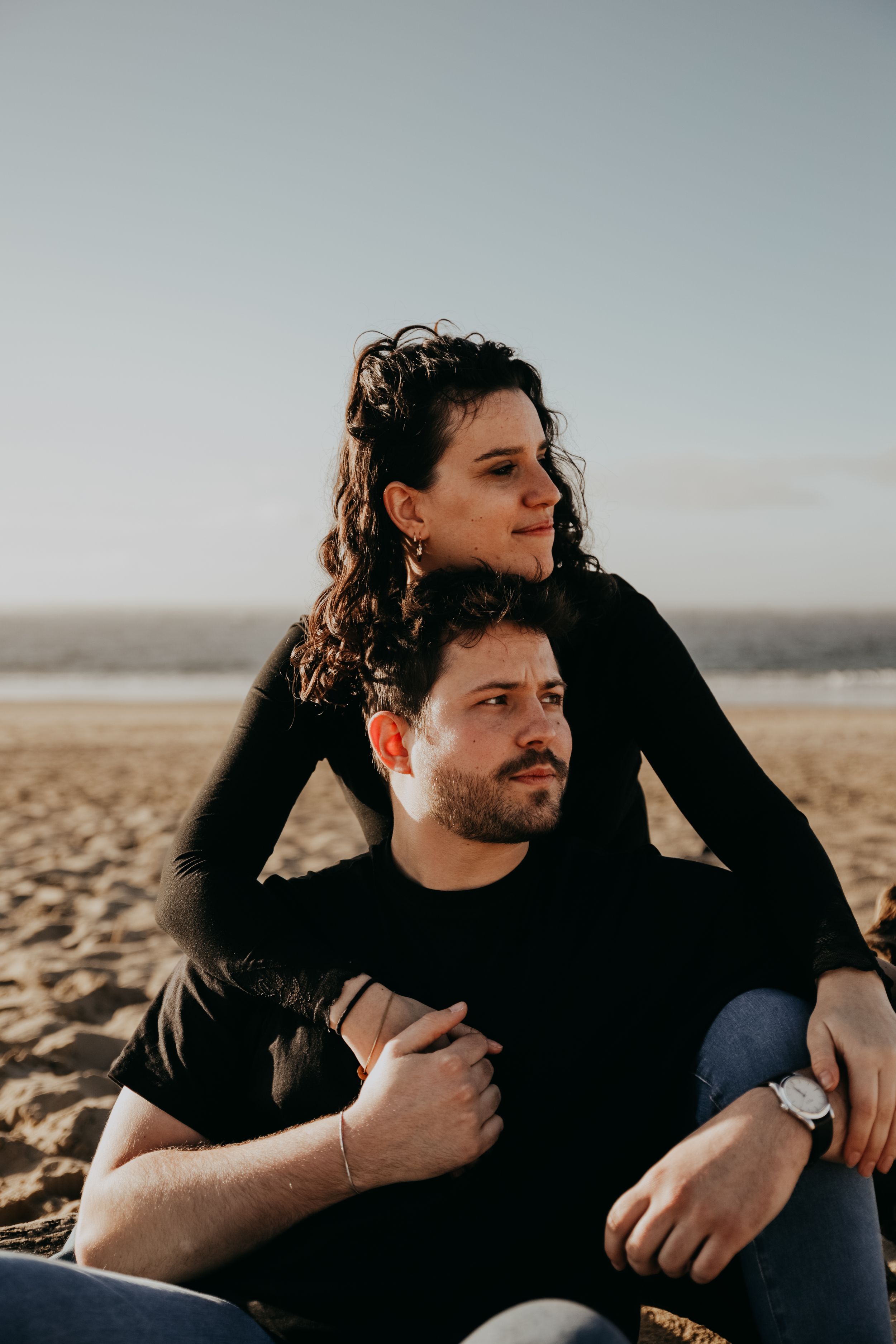 Couple sharing an intimate moment while sitting together on sandy beach.