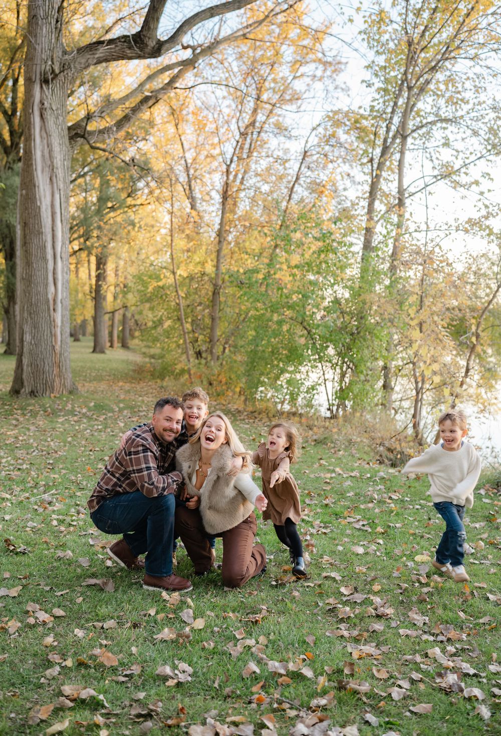 mom and dad crouching as their kids run up and give them a hug