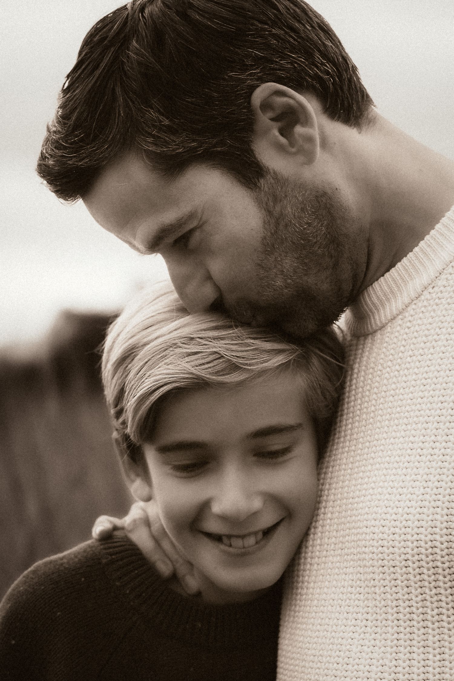 A black and white photo of a tender moment between parent and child embracing in knit sweaters in Javea with Javea photographer