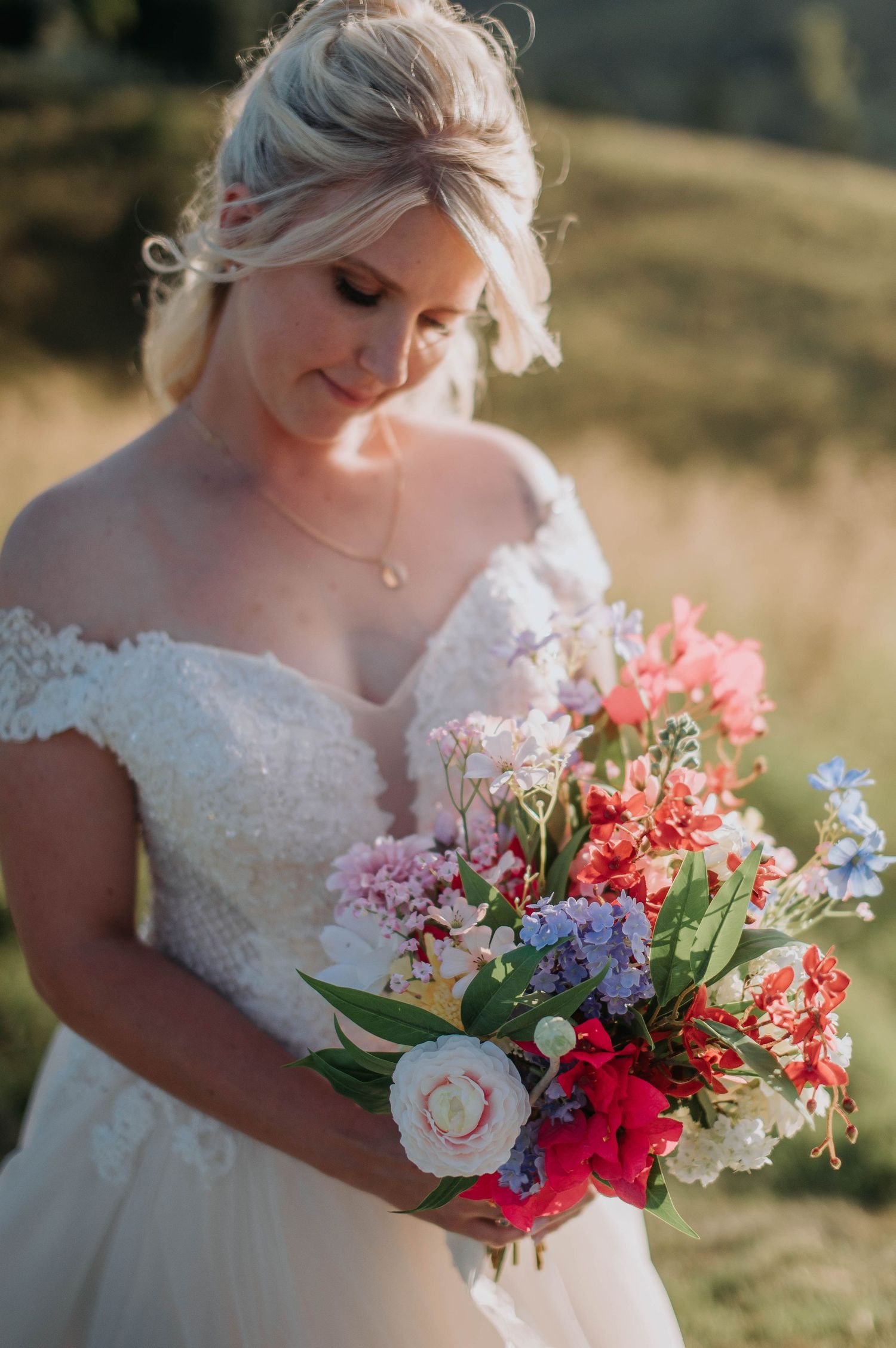 Close-up of colorful bridal bouquet with pink, red, and purple flowers.