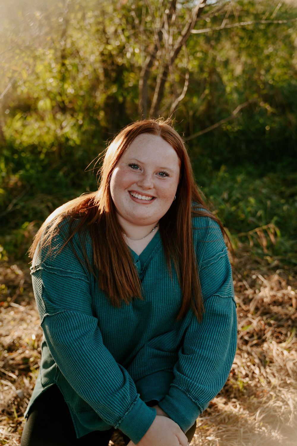 Outdoor autumn portrait in warm sunlight wearing teal sweater.