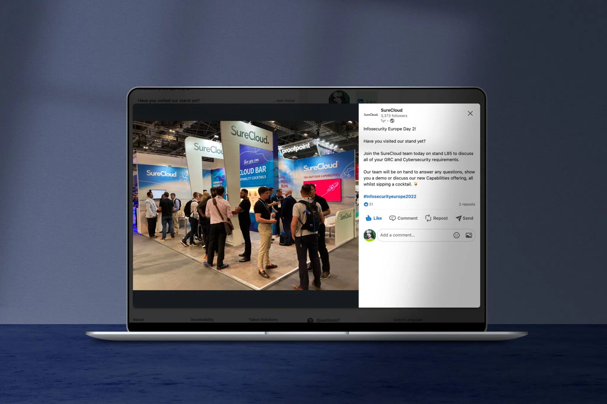 Laptop displaying a Facebook post with a busy tech conference expo hall photo showing attendees and branded booths.