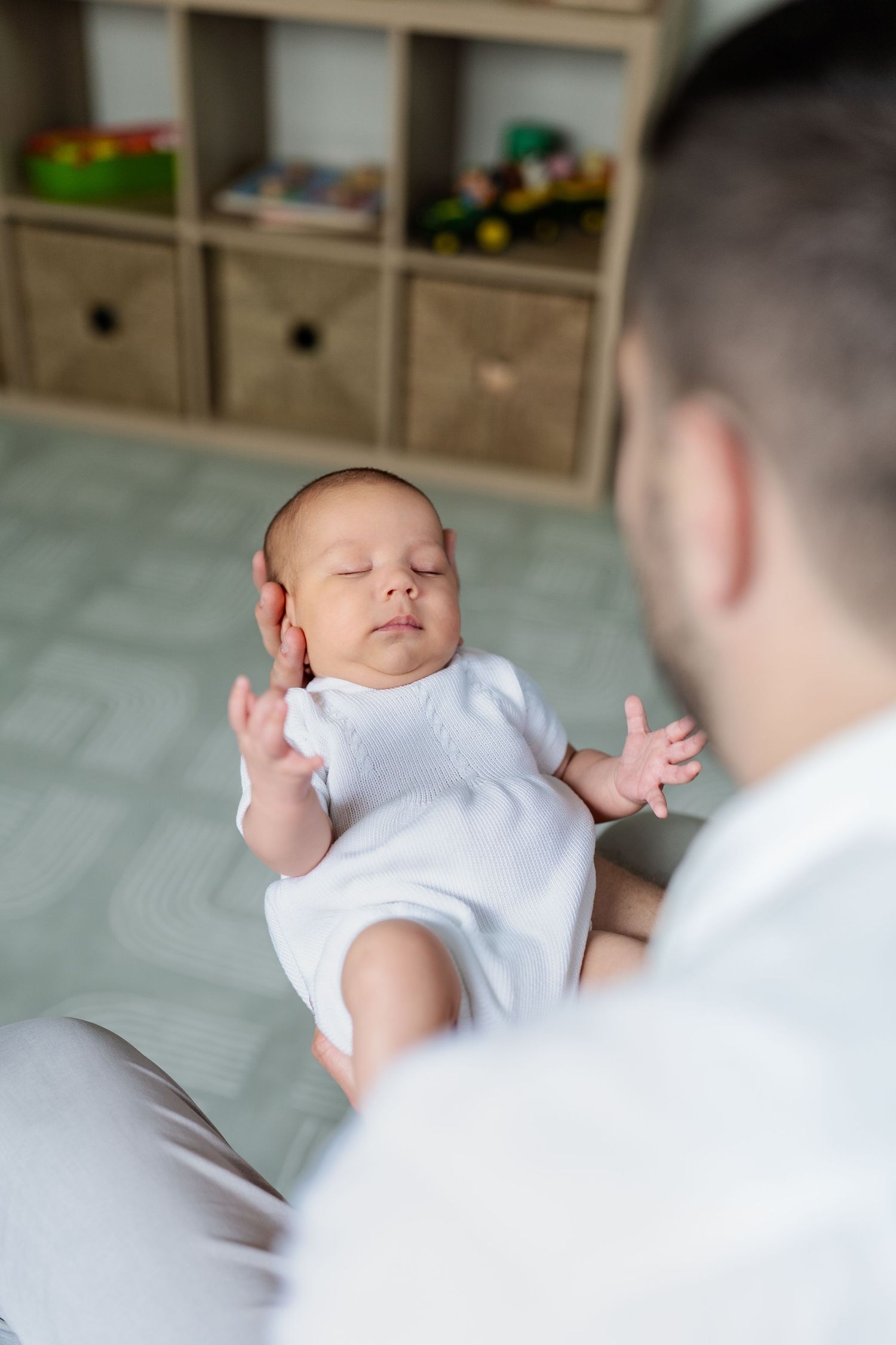 Dad holding baby in his arms in nursery