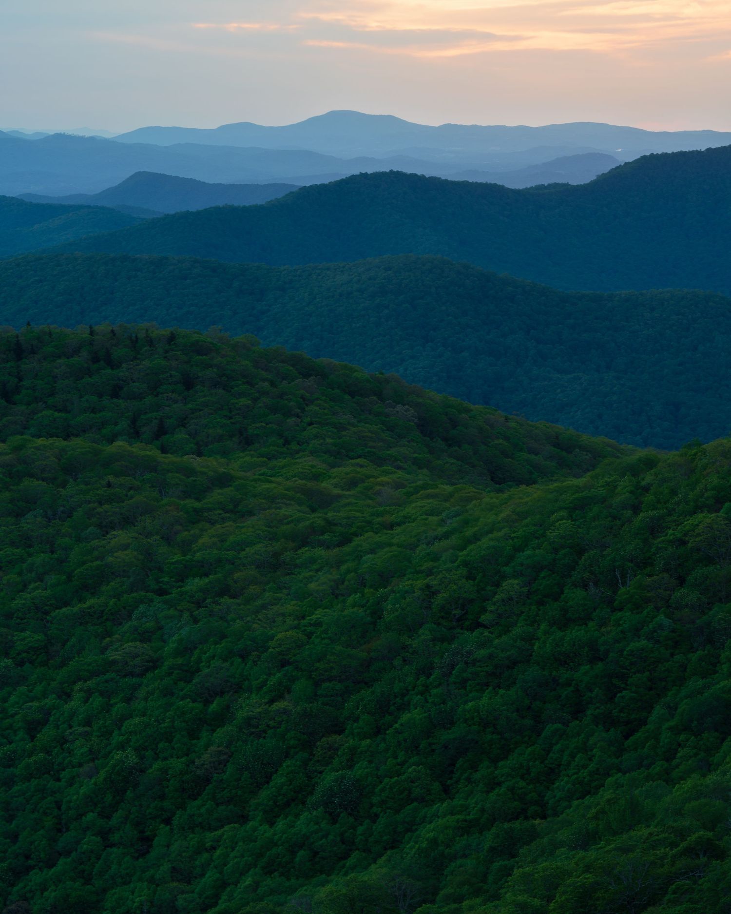 Lush green mountain ridges layered into the horizon at sunset in the Blue Ridge Mountains.