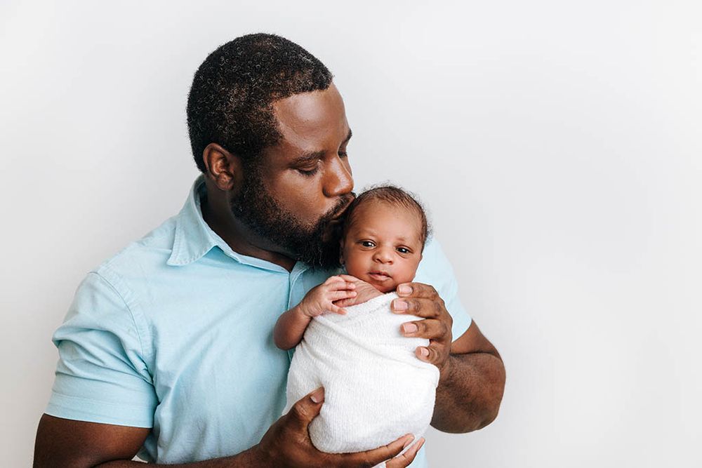 Dad holding his newborn baby boy in Hemet photography studio.