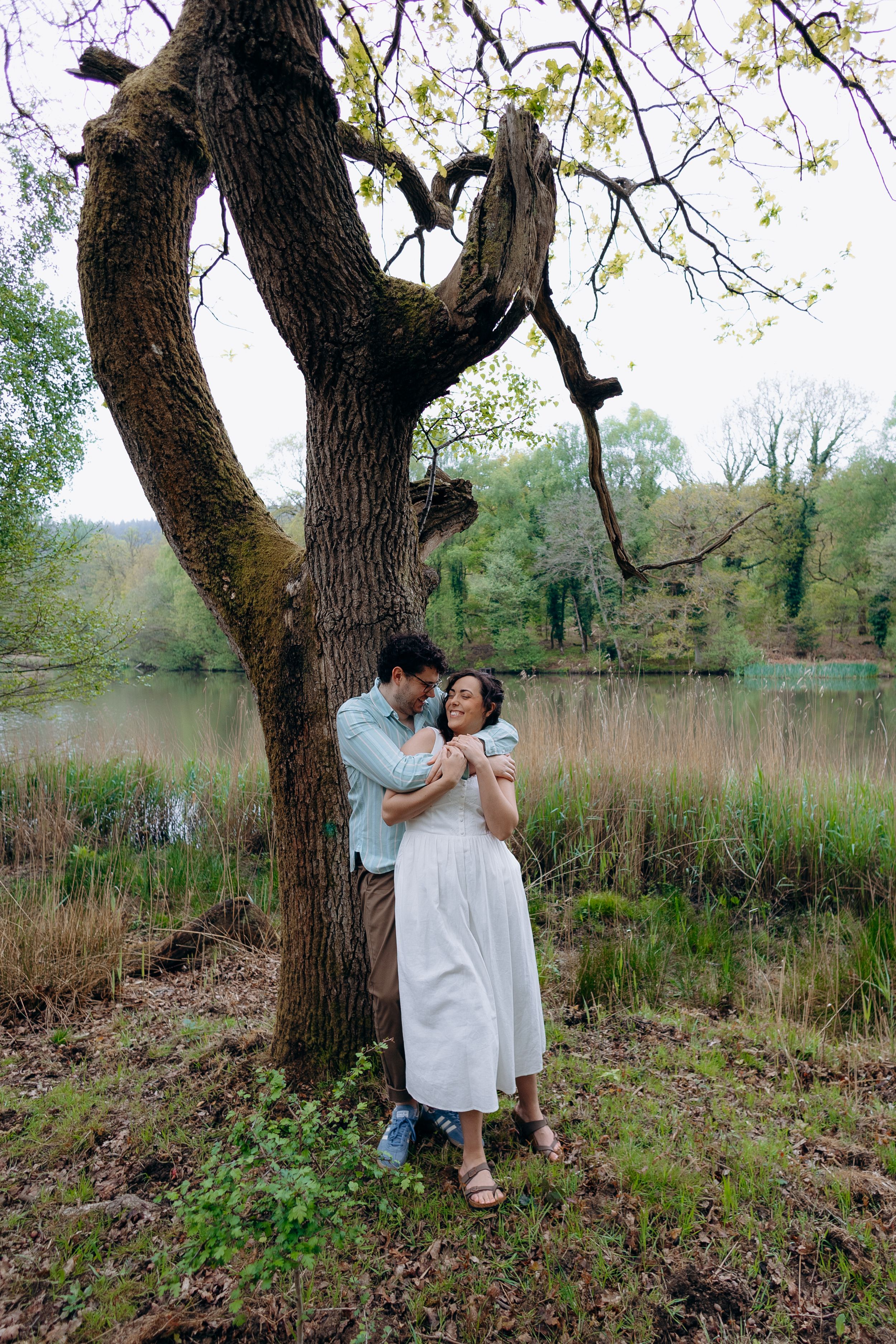 Engaged couple walking and laughing during relaxed Forest of Dean engagement photography session in nature.