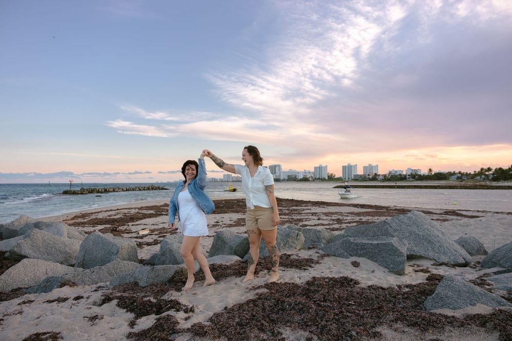 Pompano Beach engagement photographer couple spinning with skyline behind