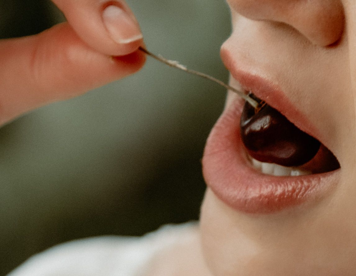Woman eating cherry for outdoor photo shoot in utah