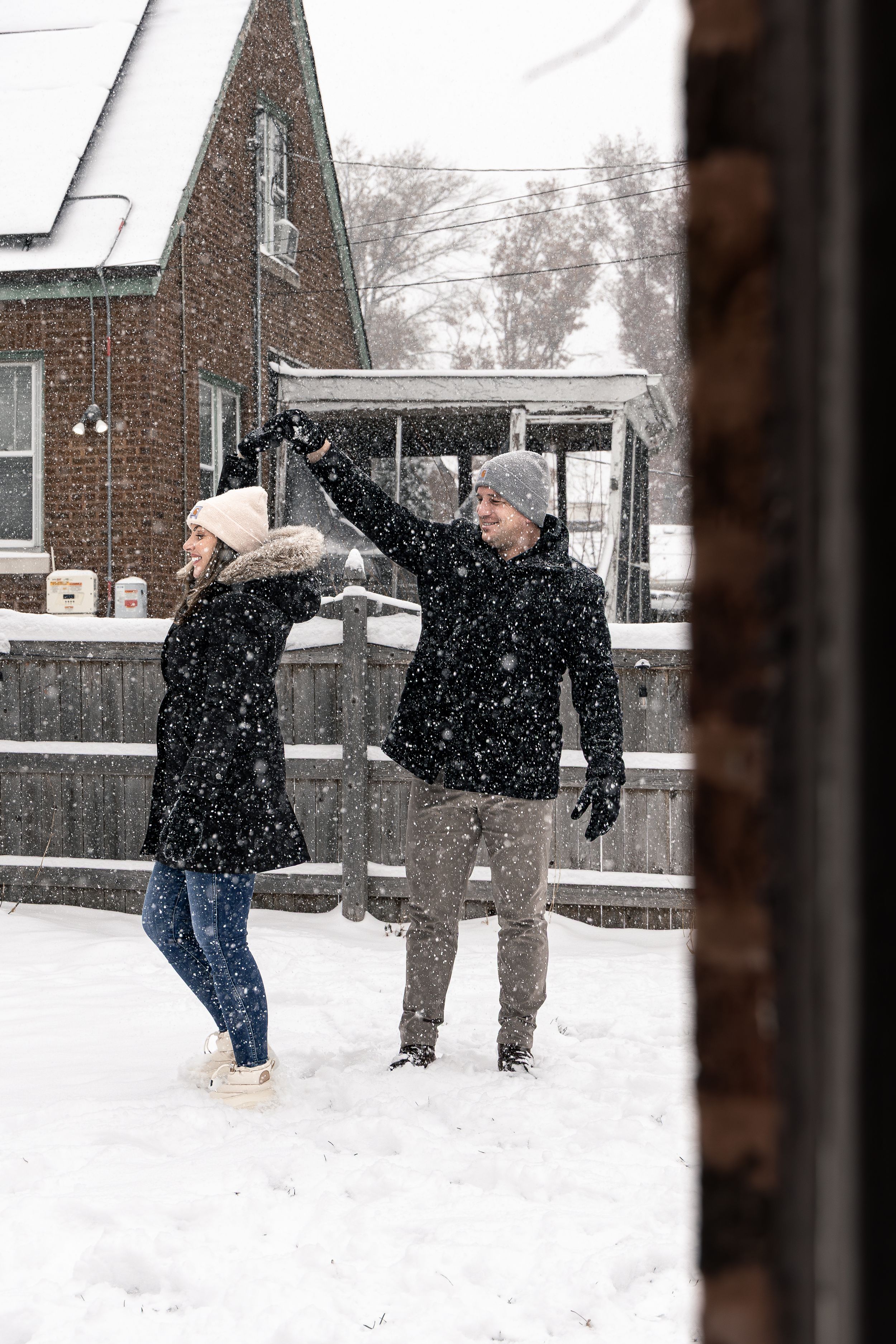 Two people play together in the snow during winter, throwing snowballs and enjoying the snowy weather.