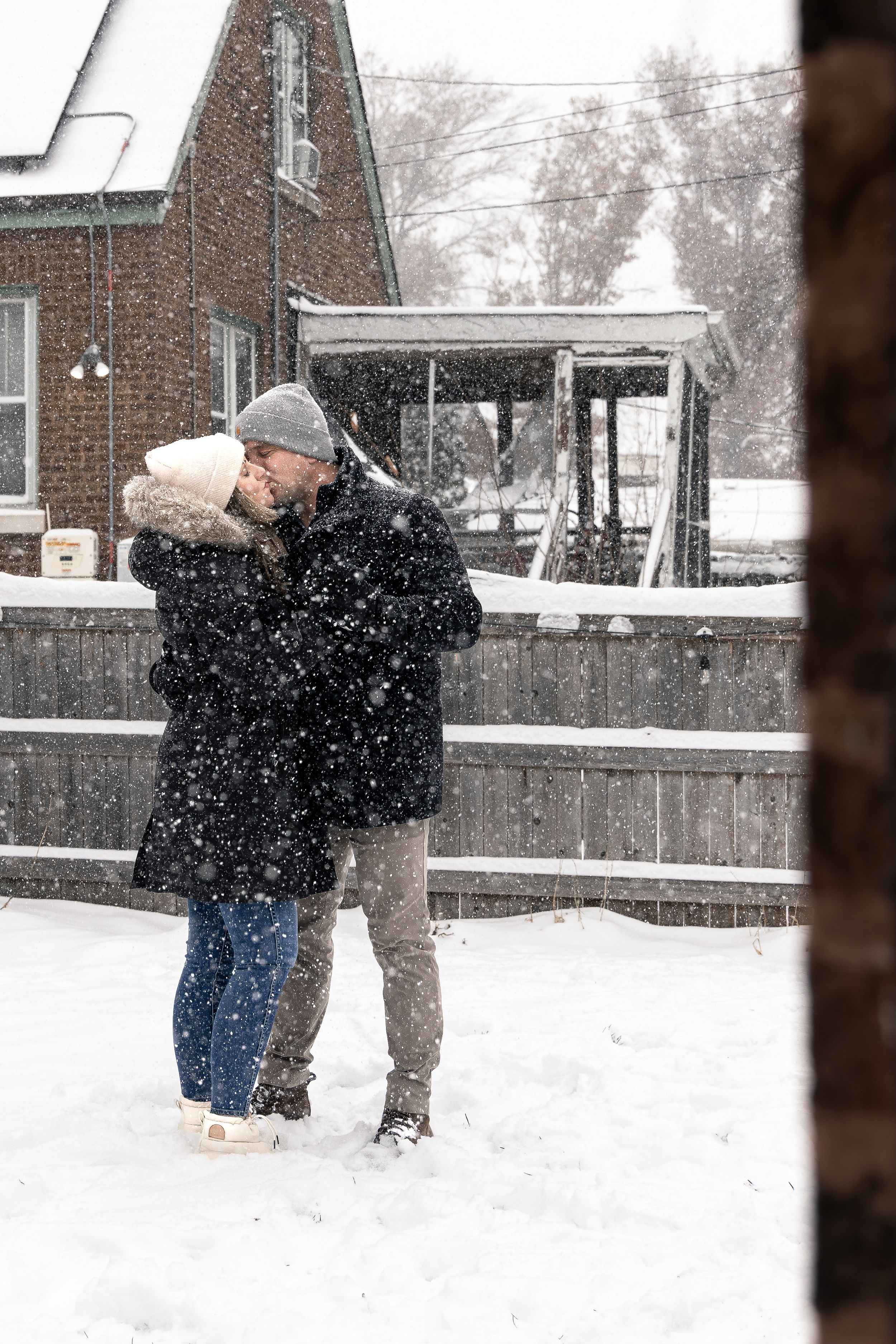 Two people play in the snow during a winter storm, throwing snowballs and enjoying the snowy weather.