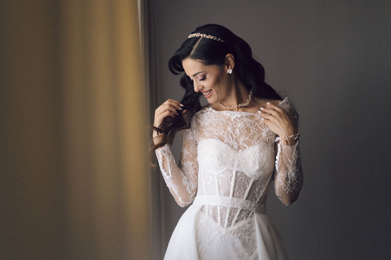 A delicate white lace wedding dress with sheer sleeves and corset bodice displayed in multiple angles.