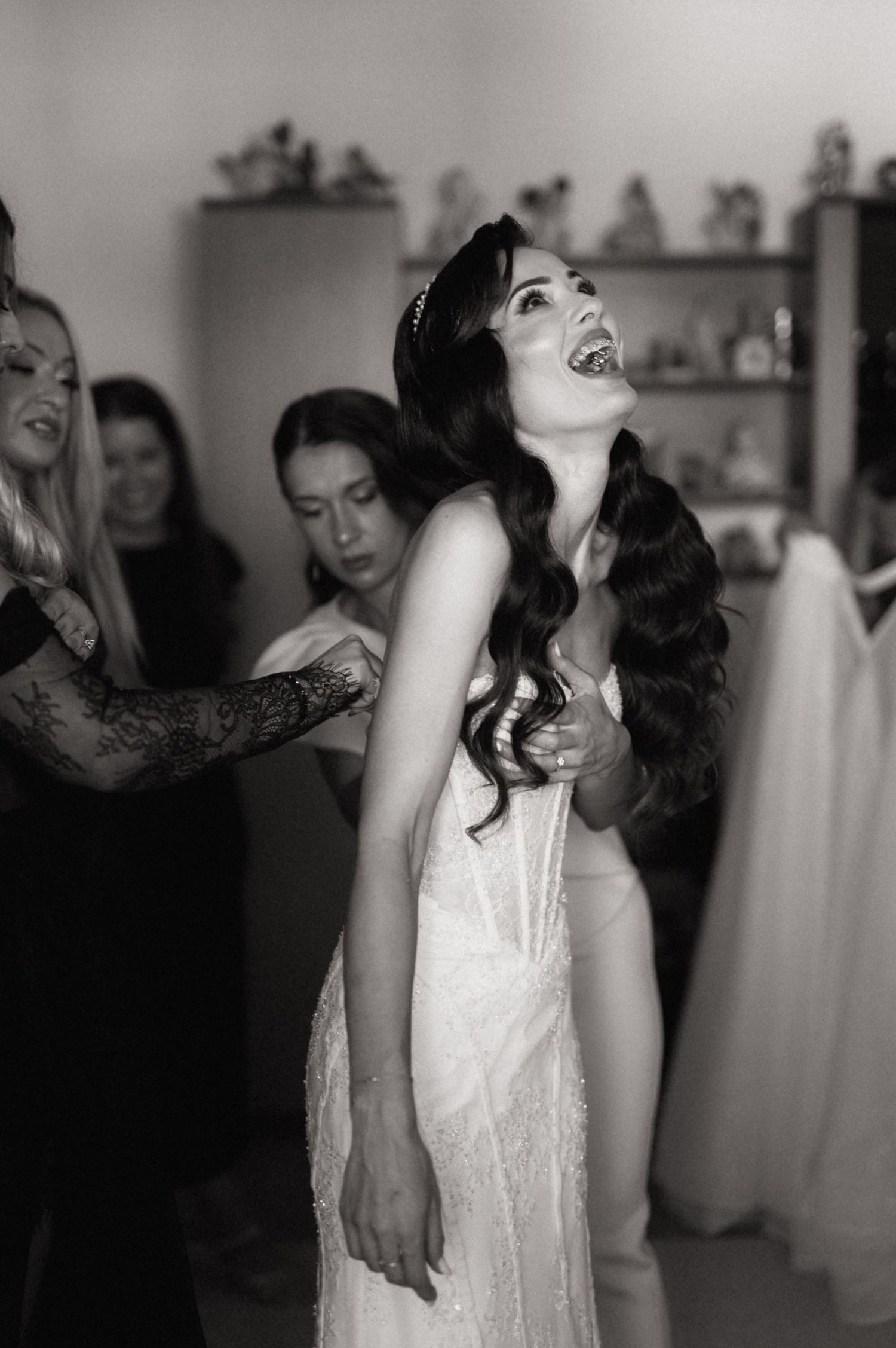 A sequence of black and white photos showing a person in a white dress laughing and dancing at what appears to be a wedding.
