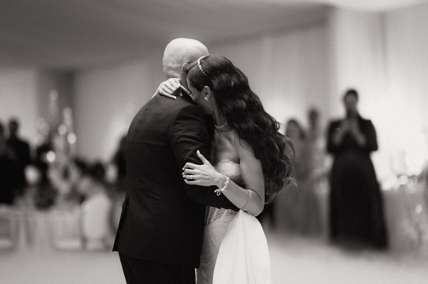 Black and white wedding photos show intimate moments between couples during their first dance at a reception.