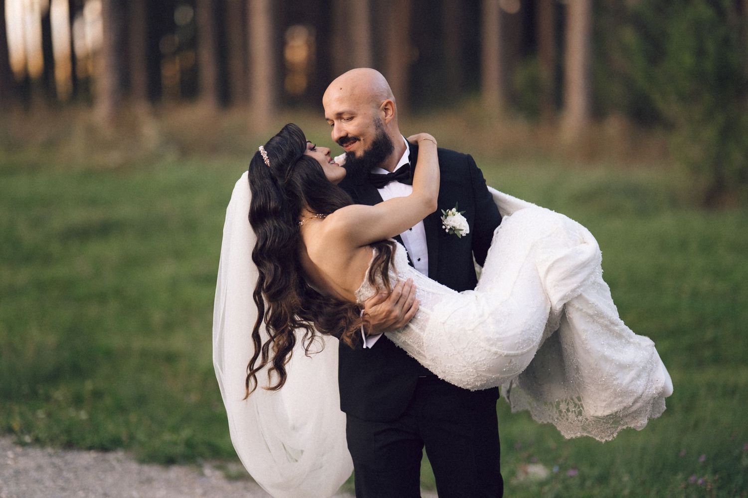 A romantic wedding couple embraces in a lush outdoor garden setting during their special day.